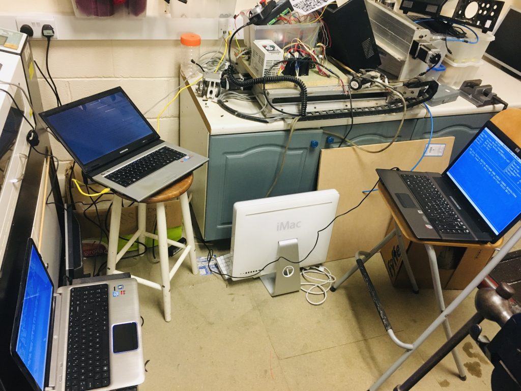Three laptops on chairs accidentally positioned as if they were three people having a meeting together, in the process of wiping