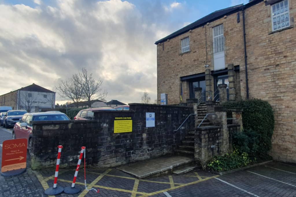 An image of a car park and the top entrance of Harpers Mill